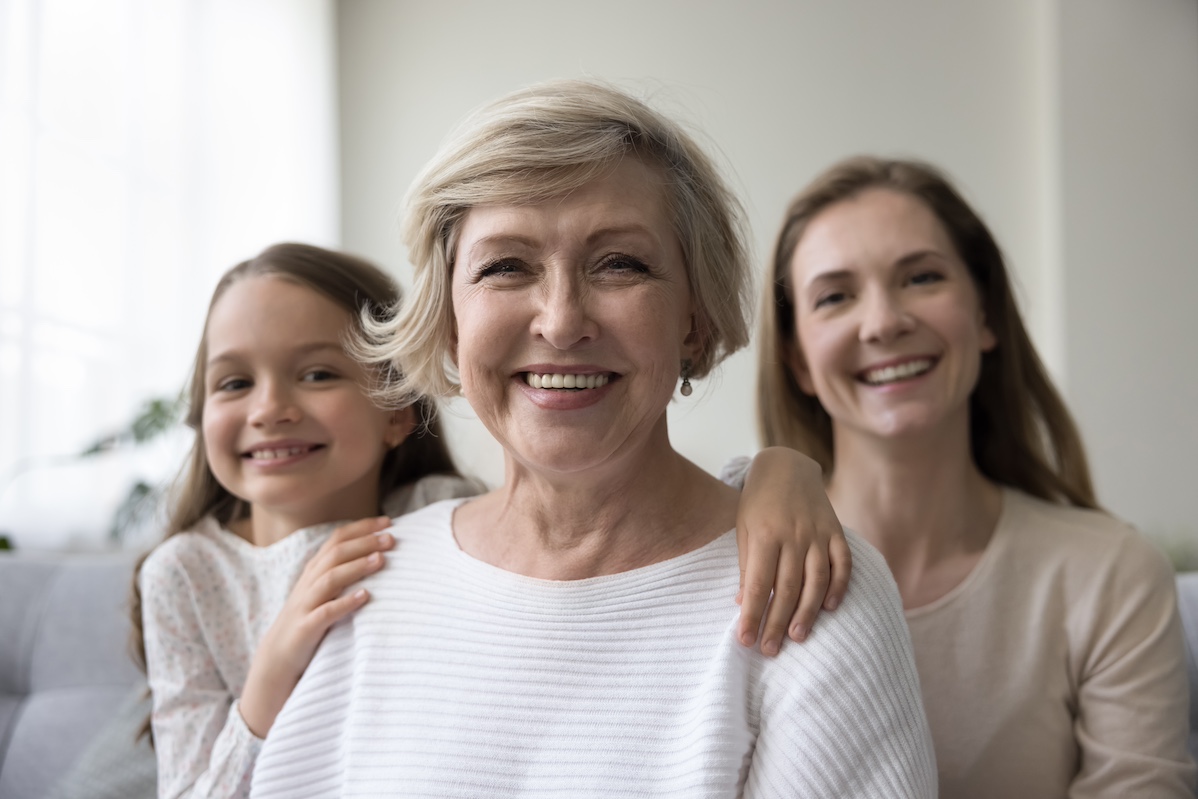 Attractive mature woman pose for picture with granddaughter and daughter